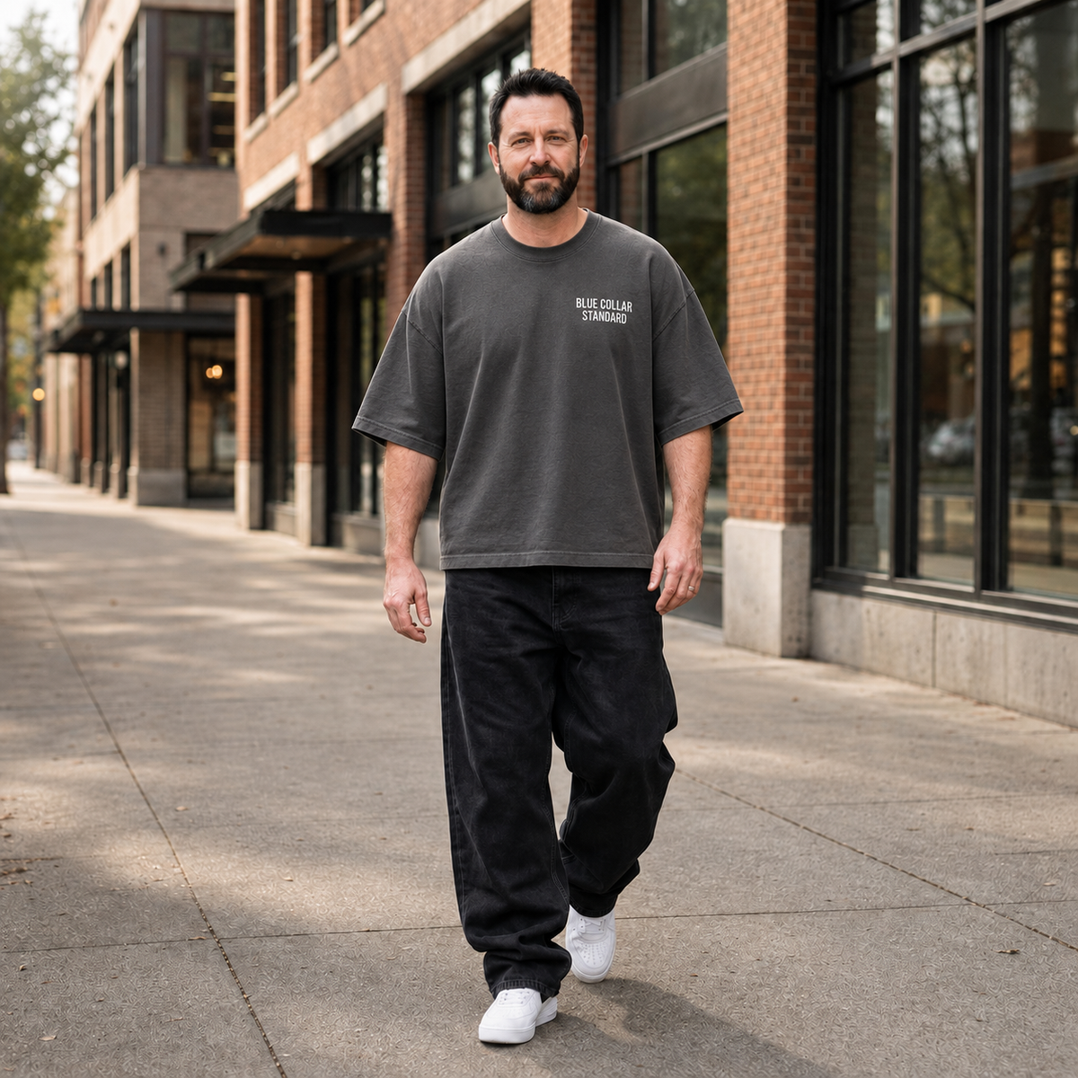 Man wearing The Concrete Tee, a garment-dyed oversized t-shirt from Blue Collar Standard, styled with black pants.