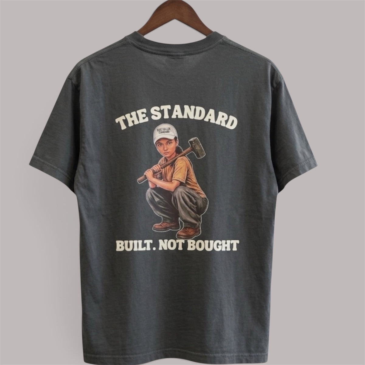 Charcoal Sledgehammer Graphic Tee, back view with hard-hat woman and Built. Not Bought. artwork